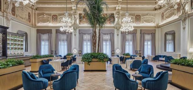 Ein elegantes Restaurant mit hohen Decken, Kristalllüstern und blauen Samtsesseln.
