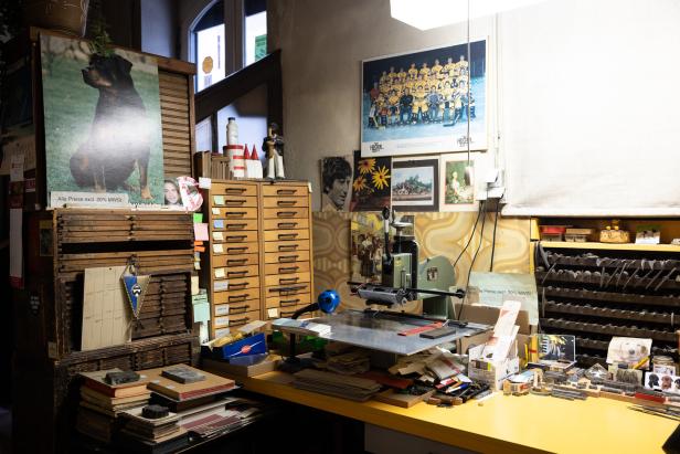 Ein Arbeitszimmer voller Druckerwerkzeuge, Bildern und anderen Gegenständen.