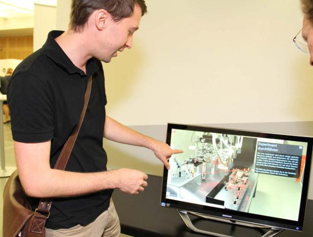 Ein Mann zeigt auf einen Bildschirm, der ein wissenschaftliches Experiment darstellt.