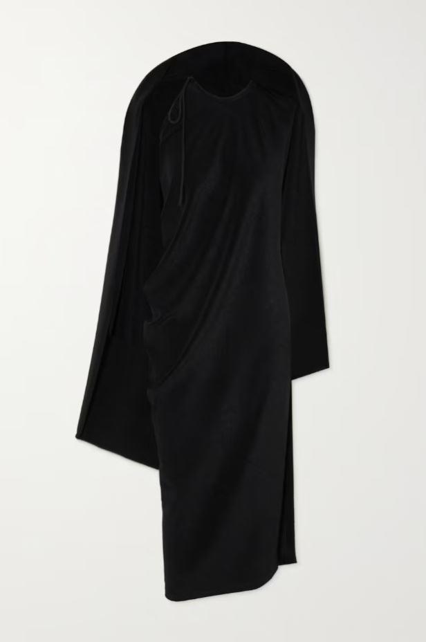 Ein schwarzes, drapiertes Kleid mit einem asymmetrischen Schnitt vor einem weißen Hintergrund.
