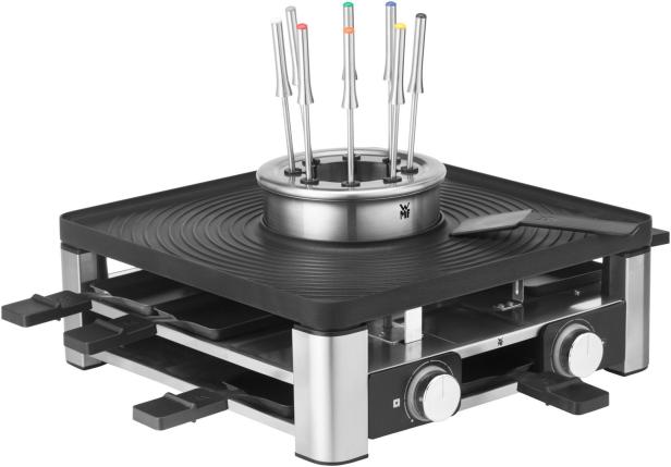 Ein Raclette- und Fondue-Set mit farbigen Fonduegabeln steht auf einem Tisch.