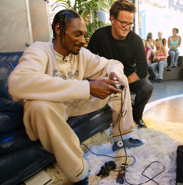 Snoop Dogg spielt Videospiele, während Matthew Perry zusieht.