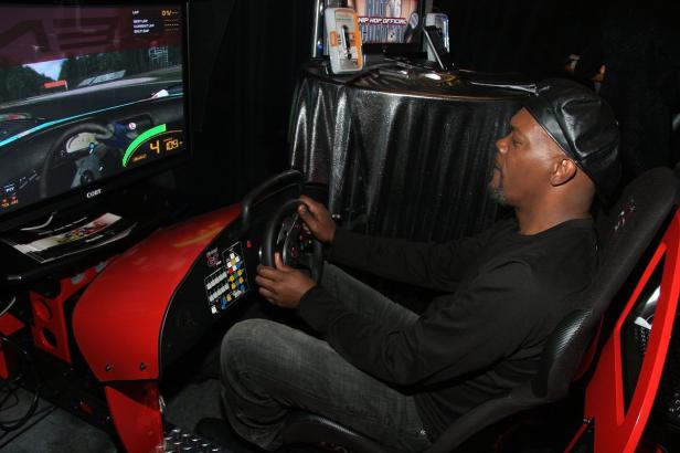 Ein Mann mit Mütze spielt ein Rennspiel an einem Simulator.