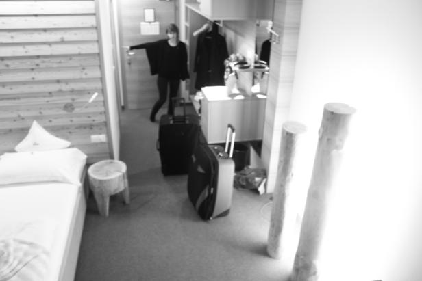 Eine Frau betritt ein Hotelzimmer mit Gepäck.