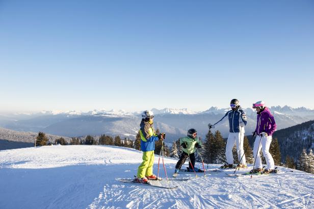 Eine Gruppe von Skifahrern genießt die Aussicht auf die schneebedeckten Berge.
