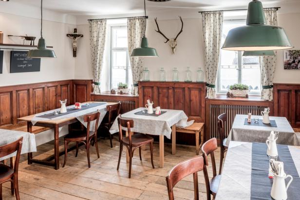 Ein traditionelles Restaurant mit Holztäfelung und gedeckten Tischen.