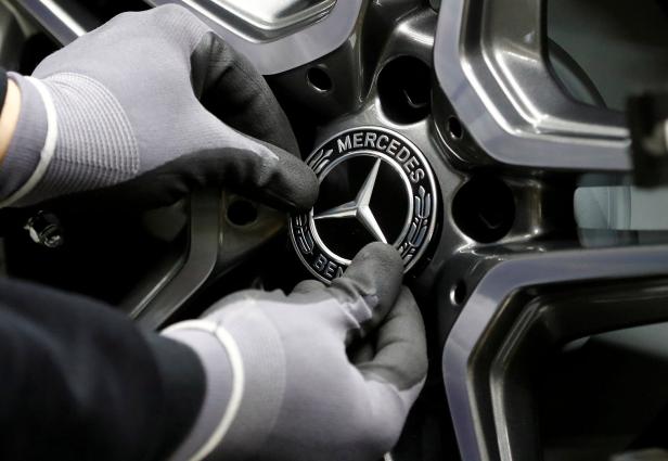 FILE PHOTO: An employee of German car manufacturer Mercedes Benz installs a hubcap at a A-class model at the production line at the Daimler factory in Rastatt Welcher deutsche Autobauer 2022 die meisten Autos verkaufte