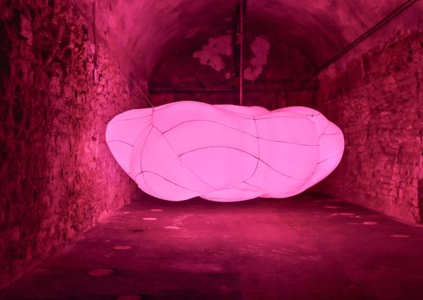 Eine rosa Wolken-Installation in einem Gewölbekeller.