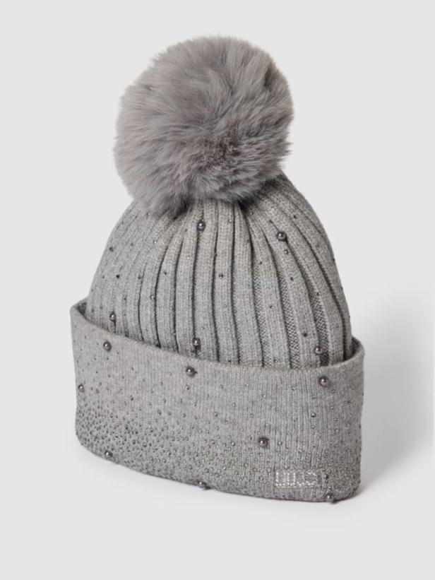 Eine graue Strickmütze mit Bommel und kleinen Zierperlen.