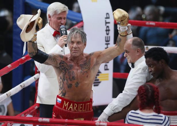 Mickey Rourke feiert seinen Sieg in einem Boxkampf mit erhobenen Armen.