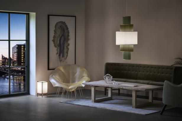 Ein Wohnzimmer mit einem Sofa, einem Tisch und einer ungewöhnlichen Lampe.