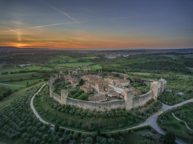 Luftaufnahme der mittelalterlichen Stadt Monteriggioni in der Toskana bei Sonnenuntergang.