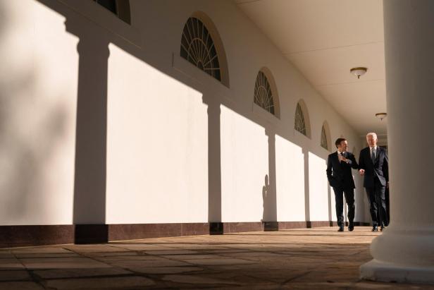 U.S. President Joe Biden and French President Emmanuel Macron walk along the Colonnade of the White House in Washington