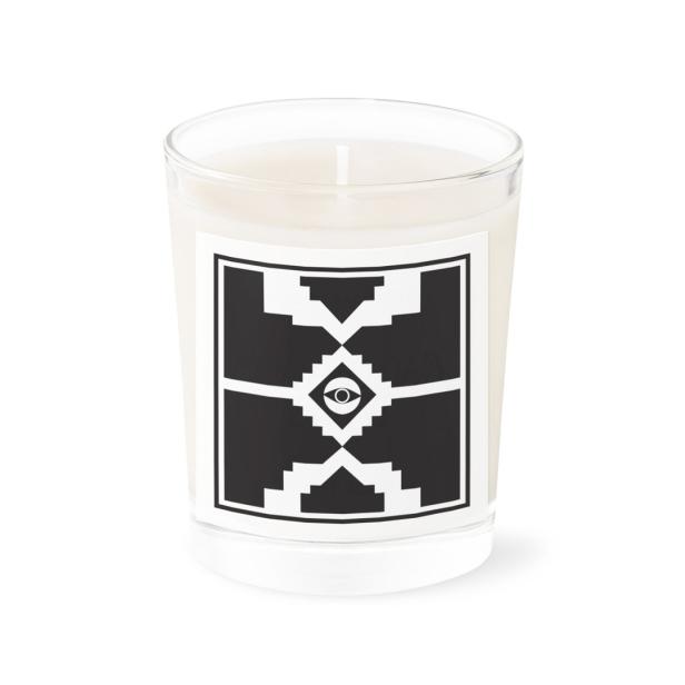 Eine Duftkerze in einem Glas mit einem schwarz-weißen Etikett mit einem Auge.