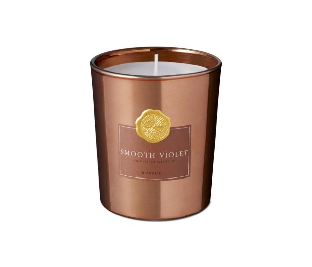 Eine „Smooth Violet“-Duftkerze der Marke Rituals in einem roségoldenen Behälter.