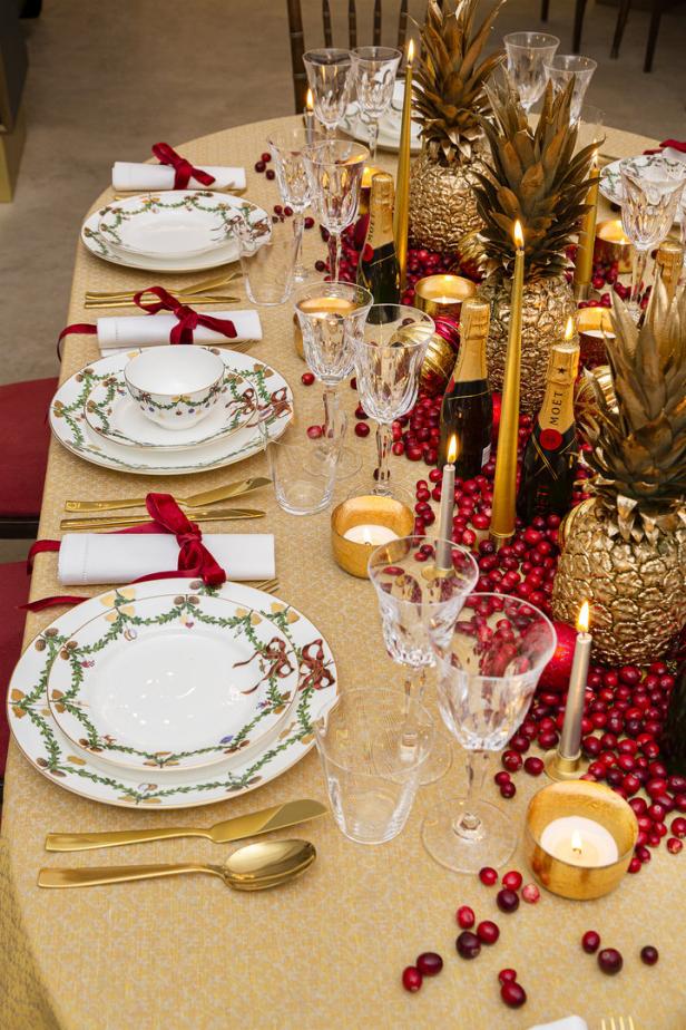Ein festlich gedeckter Tisch mit goldenen Ananas, Moët-Champagner und Weihnachtsporzellan.