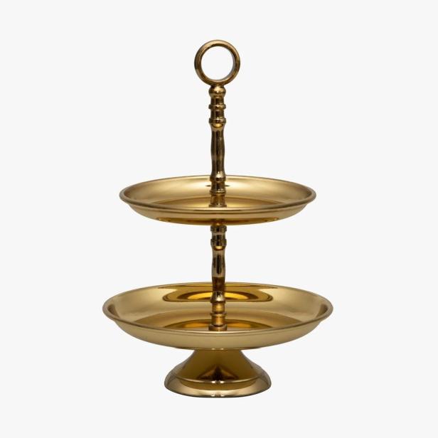 Ein goldener, zweistöckiger Servierständer auf einem weißen Hintergrund.