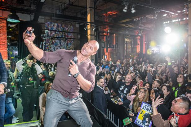 Dwayne „The Rock“ Johnson macht ein Selfie mit Fans bei einer Veranstaltung.