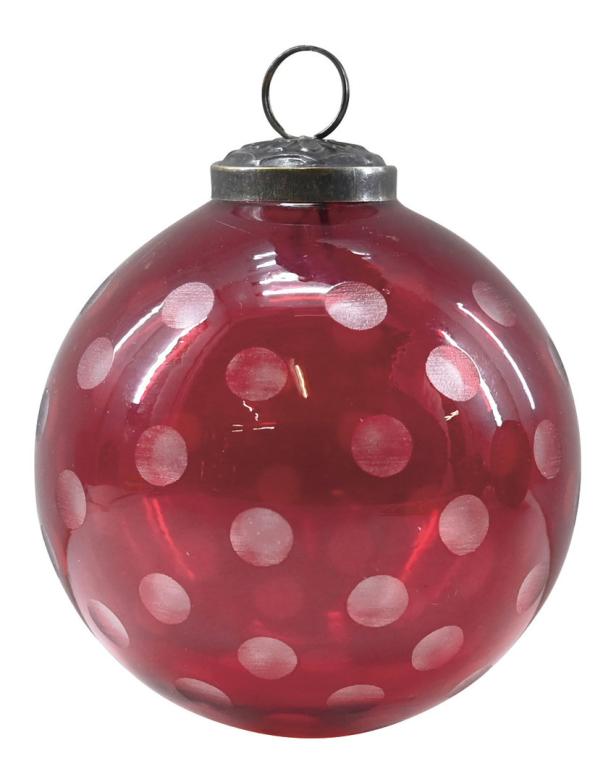 Eine rote Weihnachtskugel mit weißen Punkten hängt an einem silbernen Aufhänger.