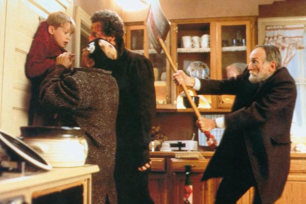 Szene aus dem Film „Kevin – Allein zu Haus“ mit Kevin, Einbrechern und einem Mann mit Axt.