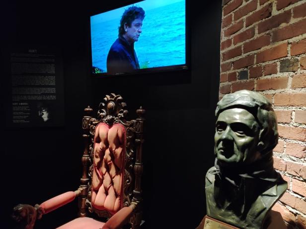 Ein Sessel, ein Johnny-Cash-Büste und ein Fernseher, der das Musikvideo „Hurt“ zeigt.