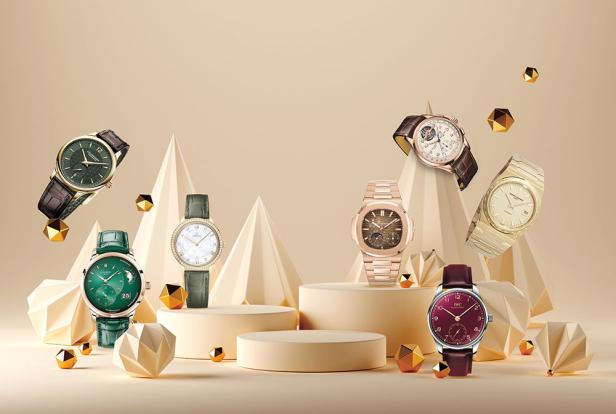 Mehrere Luxusuhren verschiedener Marken und Designs sind auf Podesten und geometrischen Formen ausgestellt.
