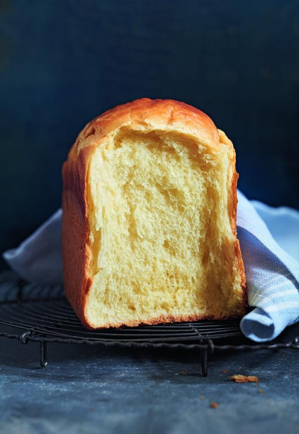 Ein angeschnittenes Brioche-Brot liegt auf einem Kühlgitter.