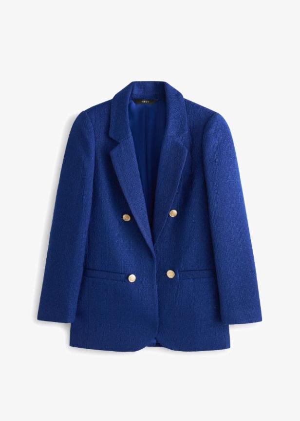 Ein blauer Blazer mit goldenen Knöpfen vor einem weißen Hintergrund.