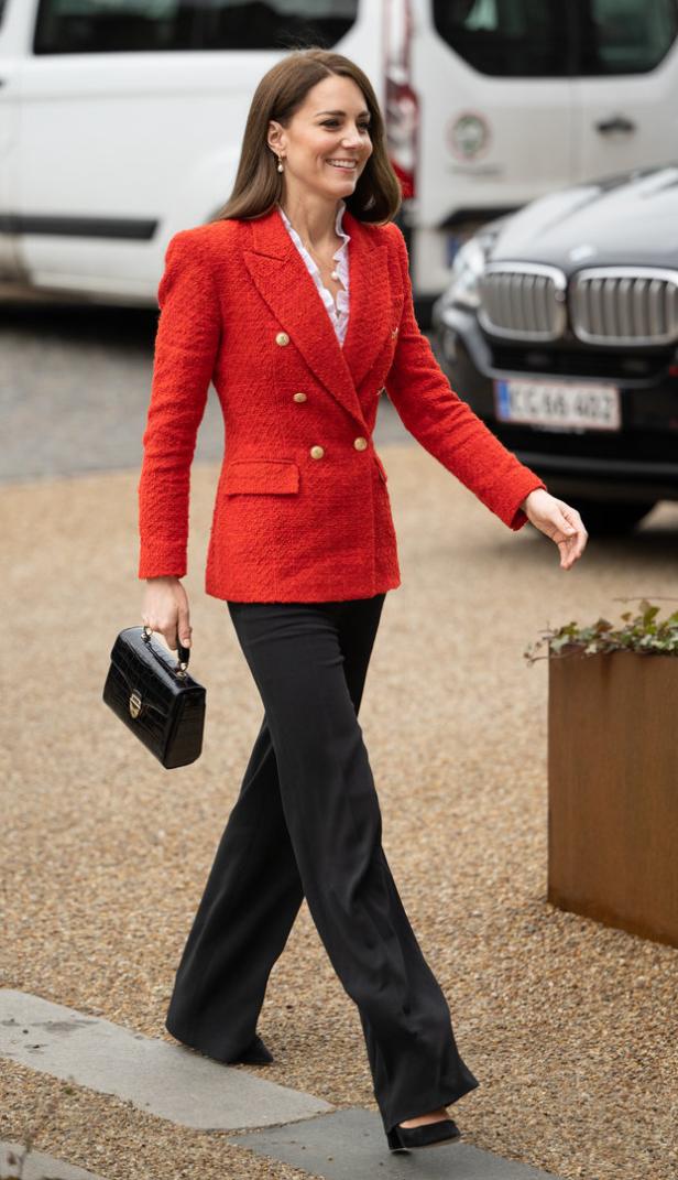 Kate Middleton trägt einen roten Blazer und eine schwarze Hose.