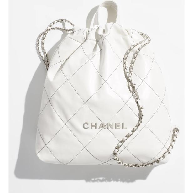 Ein weißer Chanel-Rucksack mit silberner Kette und Rautenmuster.