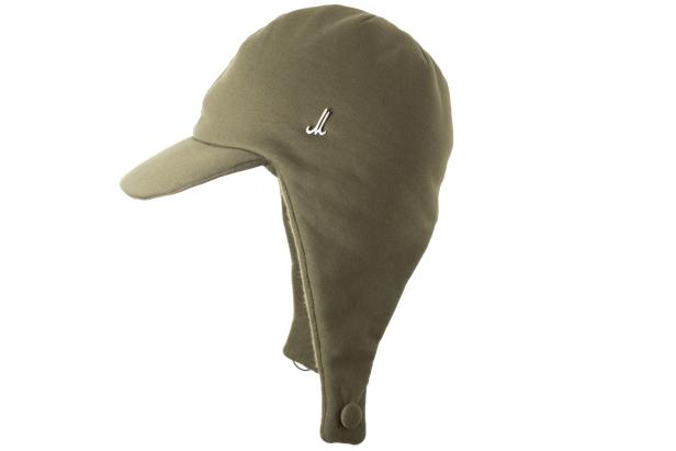 Eine khakifarbene Trappermütze mit Ohrenklappen und einem kleinen, weißen Logo.