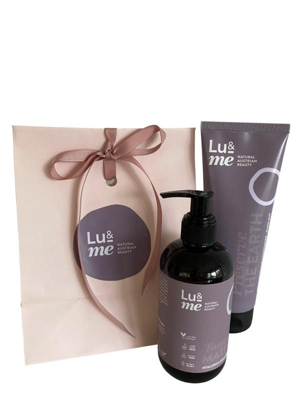 Eine Geschenktüte und zwei Produkte von „Lu&Me Natural Austrian Beauty“.