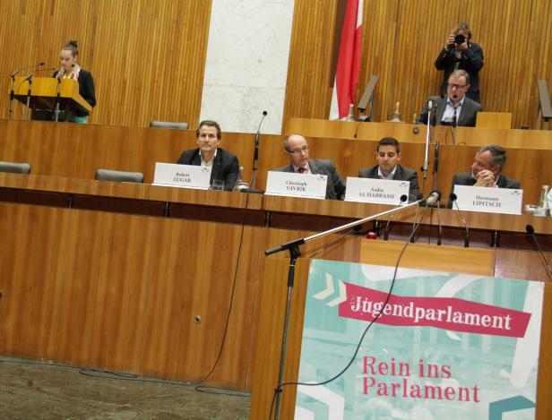 Eine Sitzung des Jugendparlaments mit mehreren Teilnehmern und einer Rednerin am Pult.