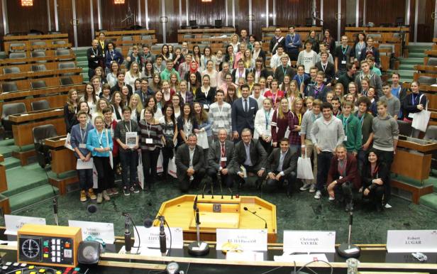 Eine große Gruppe von Menschen posiert im österreichischen Parlament für ein Foto.