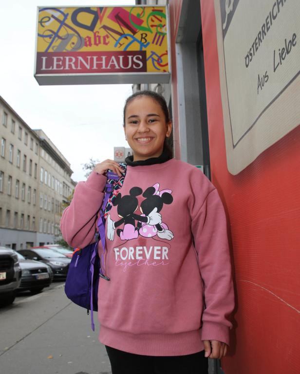 Ein junges Mädchen steht vor dem Lernhaus in Wien.