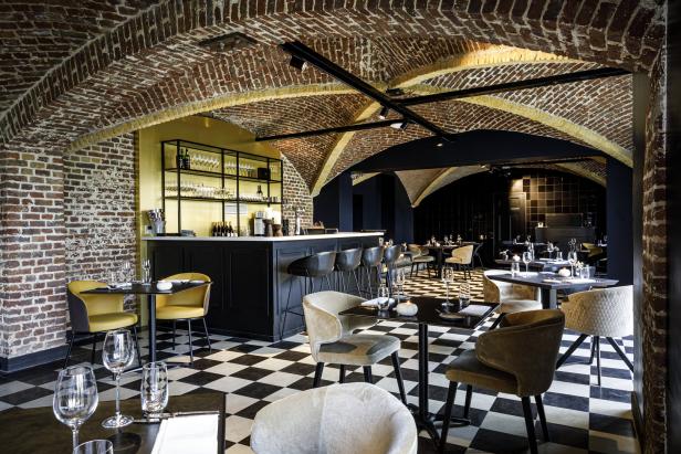 Innenansicht eines eleganten Restaurants mit Schachbrettboden und Gewölbedecke.