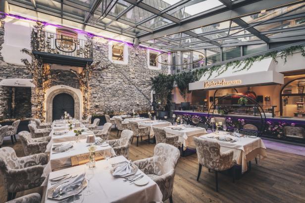 Innenansicht des Restaurants Klosterhof mit gedeckten Tischen und Steinmauern.