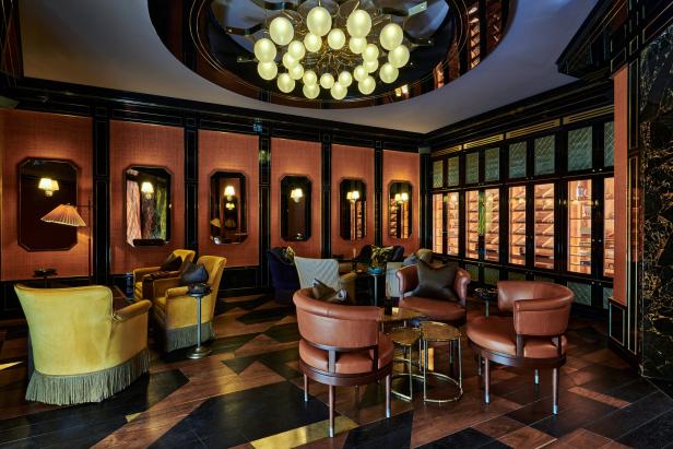 Ein luxuriöser Salon mit Sesseln, Spiegeln und einem großen Humidor an der Wand.