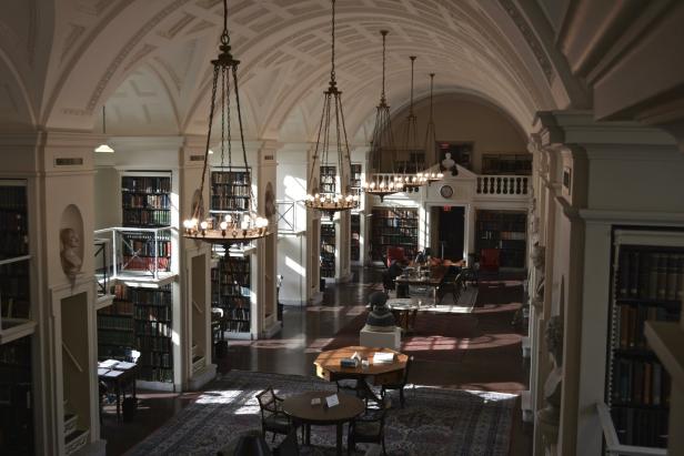Die Bibliothek ist mit Bücherregalen, Tischen und hängenden Kronleuchtern ausgestattet.