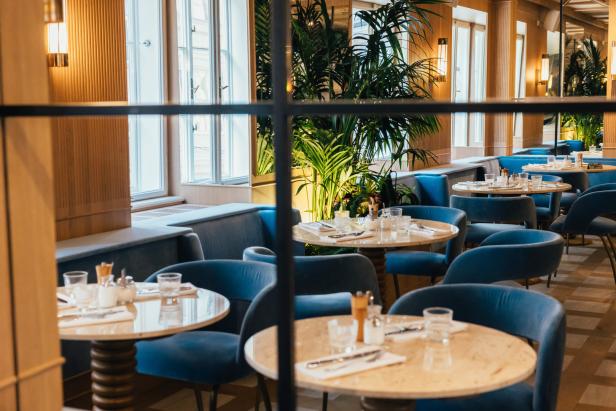 Ein elegantes Restaurant mit blauen Samtstühlen und gedeckten Tischen.