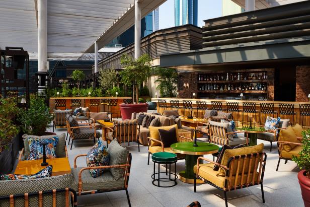 Einladende Lounge-Atmosphäre auf einer Dachterrasse mit Bar und bequemen Sitzgelegenheiten.