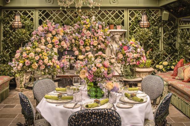 Ein festlich gedeckter Tisch in einem üppig mit Blumen geschmückten Raum.