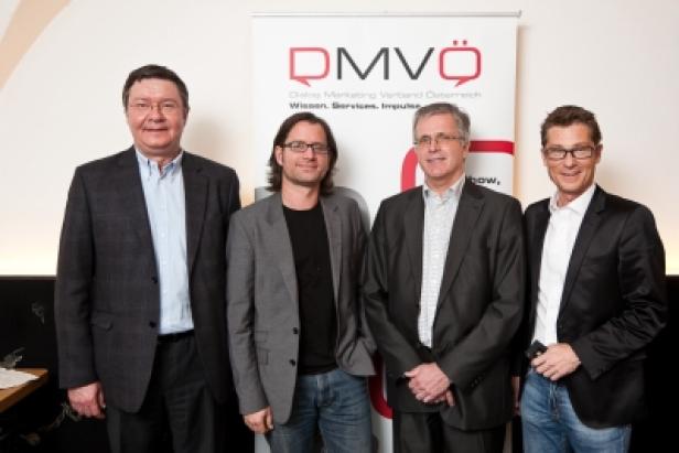 Vier Männer posieren vor einem Banner des Digital Marketing Verbands Österreich (DMVÖ).