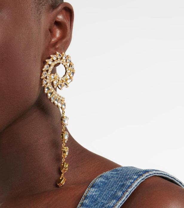 Nahaufnahme eines Models mit einem großen, goldenen Ohrring mit Strasssteinen.