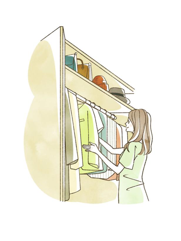Eine Frau sucht in ihrem Kleiderschrank nach Kleidung.