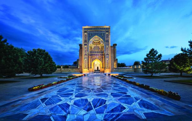 Der kunstvoll verzierte Eingangsbereich einer Moschee in Samarkand bei Dämmerung.