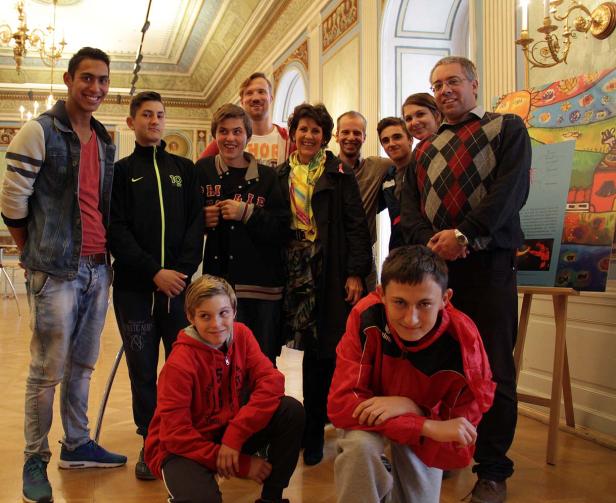 Eine Gruppe von Menschen posiert in einem eleganten Raum für ein Foto.