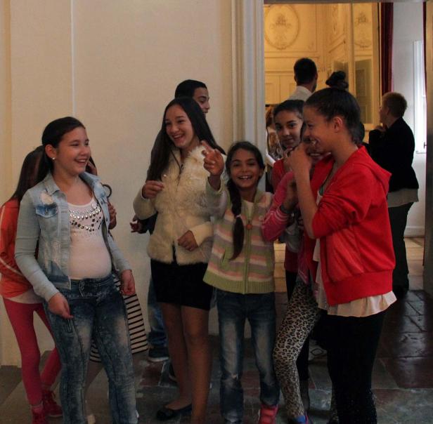 Eine Gruppe lachender Mädchen steht in einem Flur.