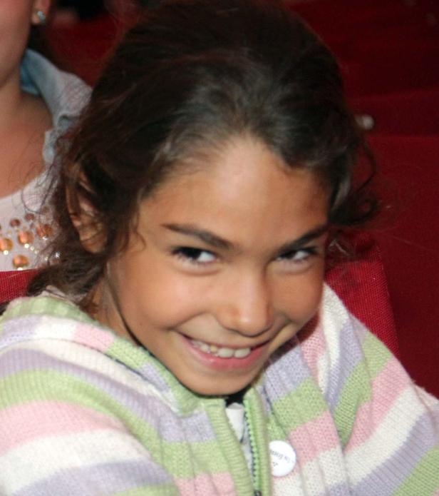 Ein junges Mädchen lächelt in die Kamera.