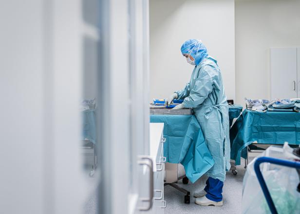 Eine Frau in OP-Kleidung bereitet Instrumente für eine Operation vor.